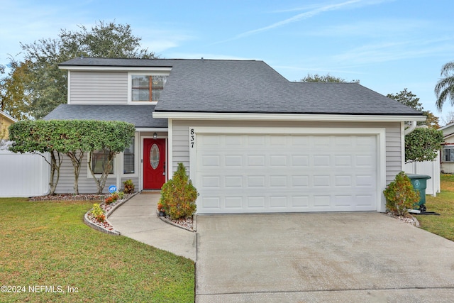 front facade featuring a garage and a front lawn