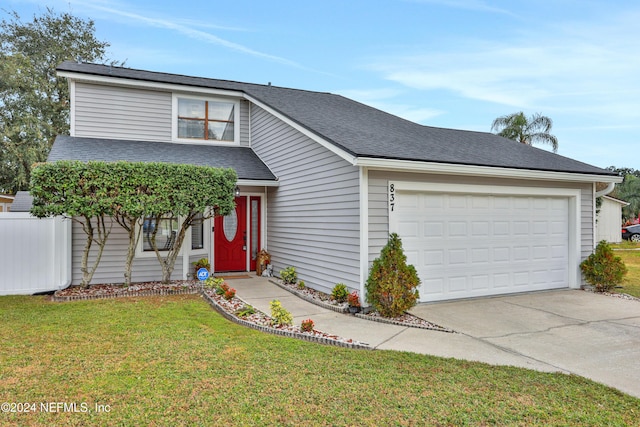 view of front of property featuring a front yard and a garage