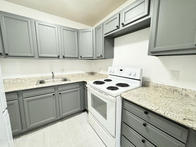 kitchen featuring light stone countertops, gray cabinets, white range with electric stovetop, and sink