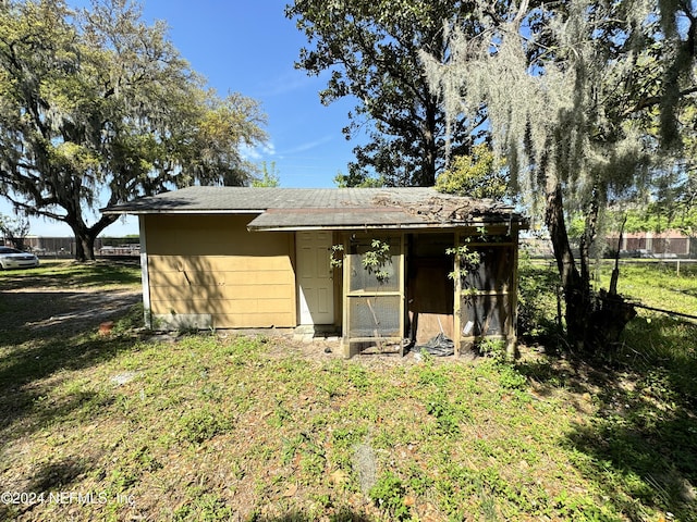 back of property with a yard and an outbuilding