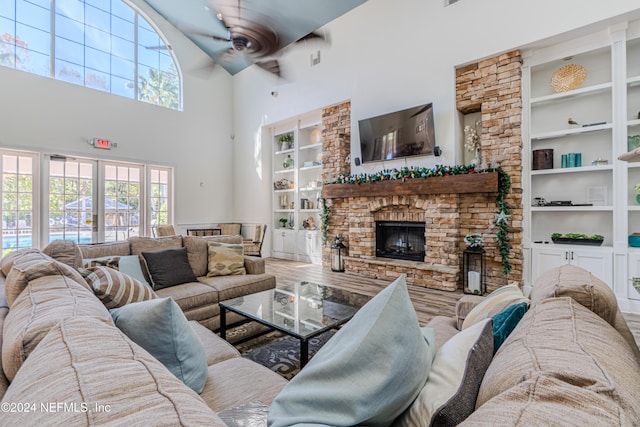 8550 Touchton Rd Unit 1226, Jacksonville, FL 32216 - living room with ceiling fan, a stone fireplace, built in features, a towering ceiling, and hardwood / wood-style flooring