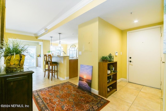 entrance foyer with light tile patterned flooring and ornamental molding