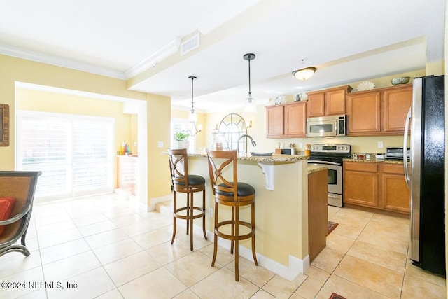 kitchen with stainless steel appliances, a kitchen breakfast bar, light stone counters, pendant lighting, and a center island with sink