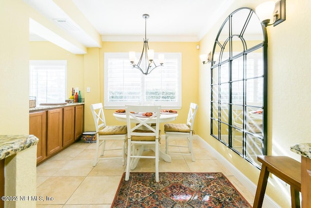 tiled dining space featuring plenty of natural light, breakfast area, crown molding, and an inviting chandelier