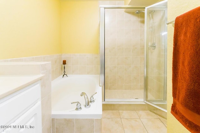 bathroom featuring tile patterned flooring, vanity, and shower with separate bathtub