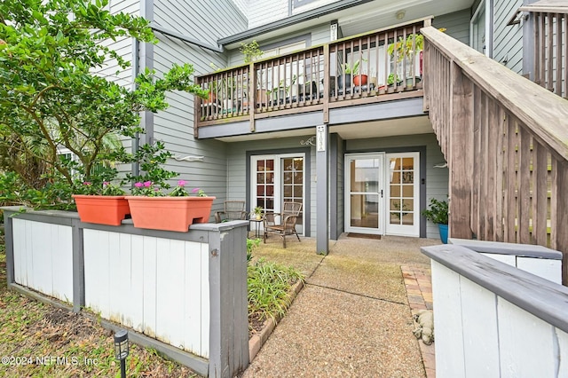 rear view of property featuring a balcony and french doors