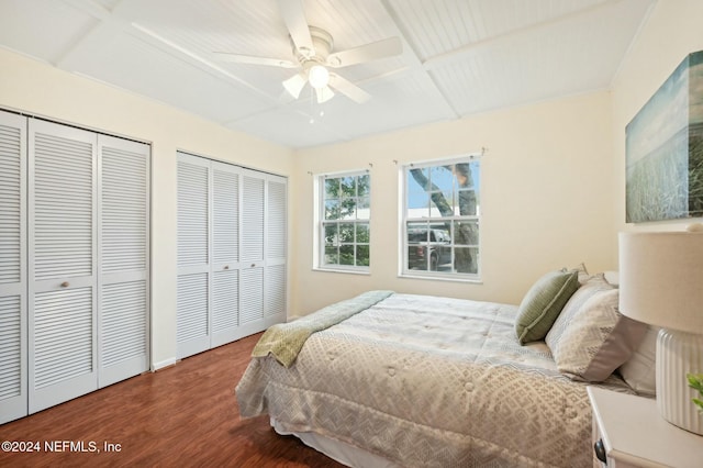 bedroom featuring beam ceiling, multiple closets, ceiling fan, coffered ceiling, and hardwood / wood-style floors