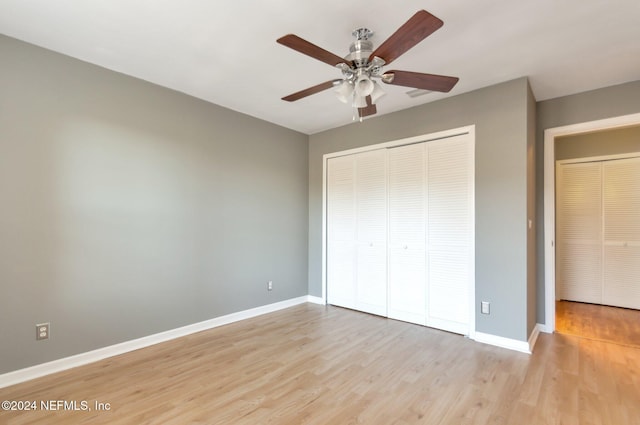 unfurnished bedroom featuring a closet, light hardwood / wood-style flooring, and ceiling fan