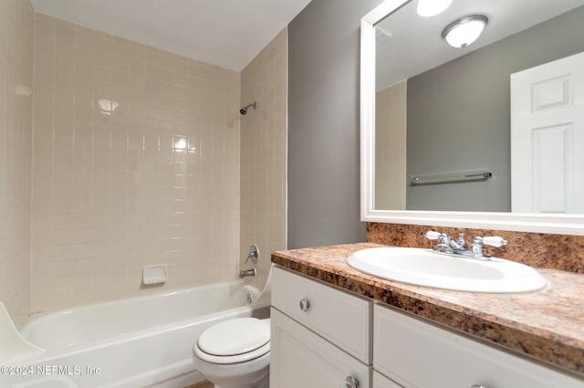 full bathroom with vanity, tiled shower / bath combo, and toilet