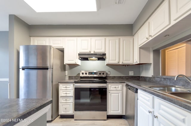 kitchen with white cabinets, stainless steel appliances, light hardwood / wood-style flooring, and sink