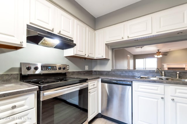 kitchen with appliances with stainless steel finishes, light wood-type flooring, ceiling fan, sink, and white cabinets