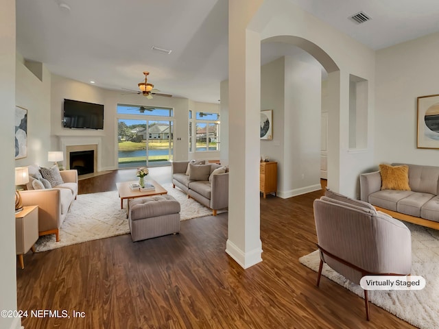 living room with ceiling fan and dark hardwood / wood-style flooring