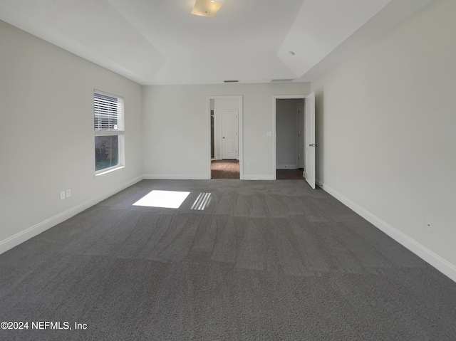 carpeted spare room featuring vaulted ceiling