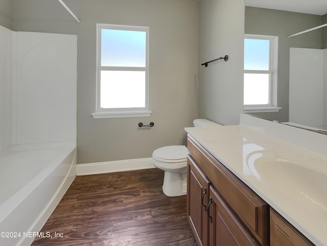 full bathroom featuring wood-type flooring, vanity, toilet, and a wealth of natural light