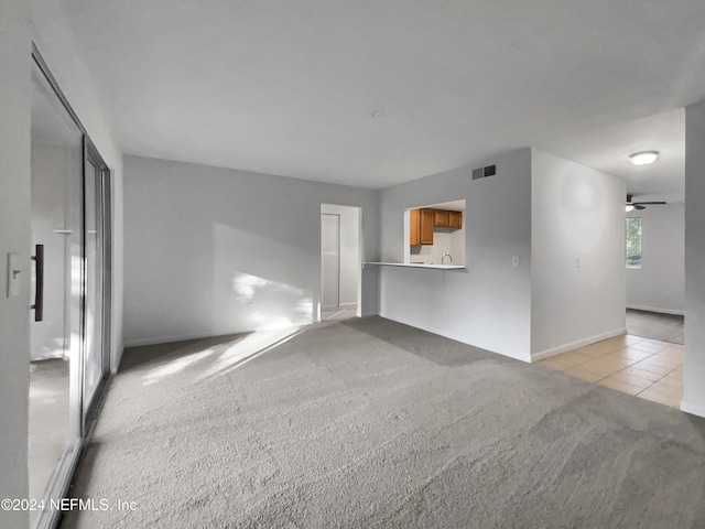 8849 Old Kings Rd S Unit 181, Jacksonville, FL 32257 - unfurnished living room featuring light colored carpet, light tile patterned flooring, and a ceiling fan