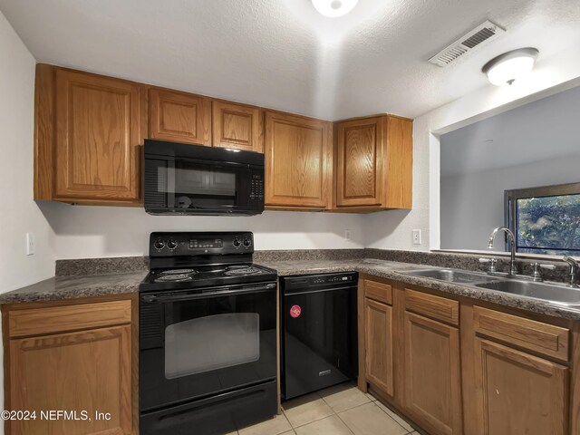8849 Old Kings Rd S Unit 181, Jacksonville, FL 32257 - kitchen with black appliances, dark countertops, brown cabinetry, and light tile patterned flooring