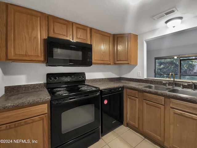 kitchen with black appliances, light tile patterned floors, and sink