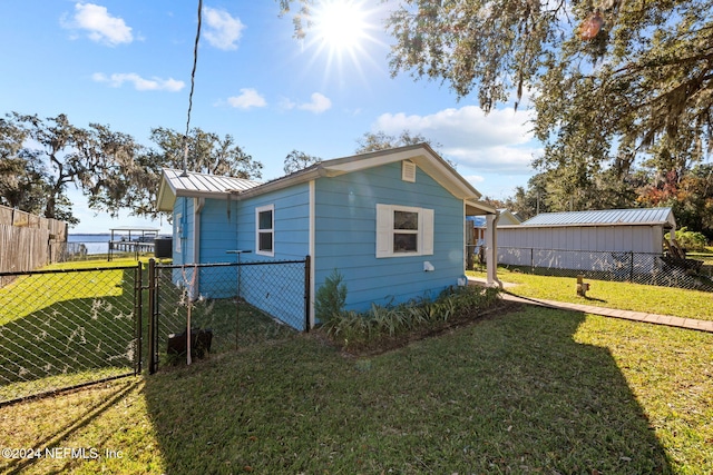 view of property exterior with a water view and a yard