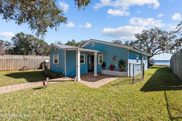 view of front facade featuring a water view and a front lawn