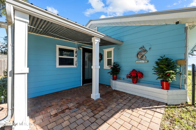 doorway to property with a porch and a patio area