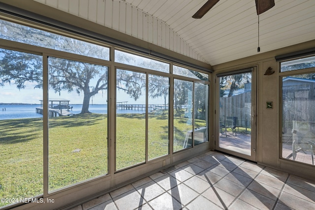 unfurnished sunroom featuring ceiling fan, a water view, and lofted ceiling