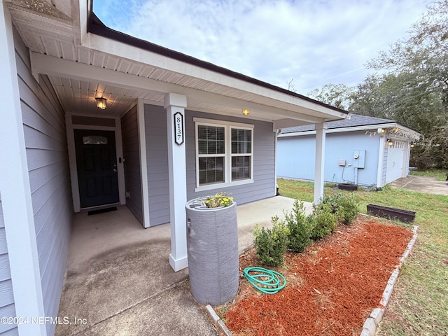 doorway to property featuring a porch and a garage