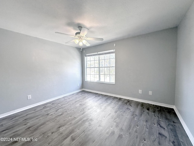 empty room featuring a textured ceiling, ceiling fan, and dark wood-type flooring