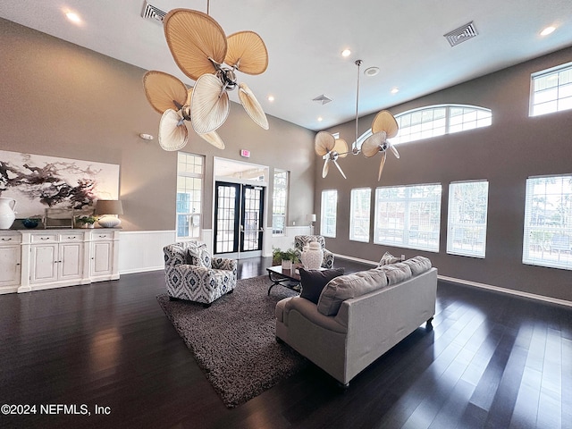 living room featuring a healthy amount of sunlight, french doors, dark hardwood / wood-style floors, and ceiling fan with notable chandelier