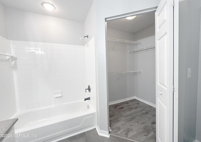 bathroom featuring hardwood / wood-style floors,  shower combination, and a textured ceiling