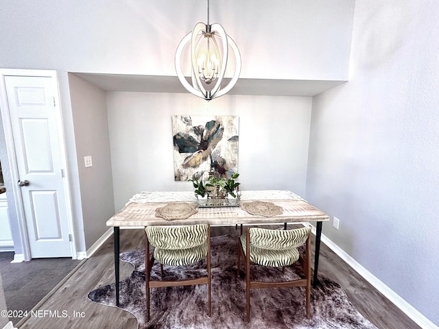 dining space featuring dark hardwood / wood-style flooring and an inviting chandelier