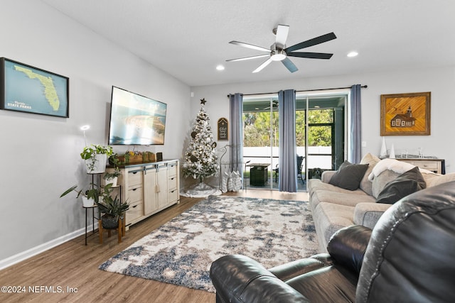 living room with wood-type flooring and ceiling fan