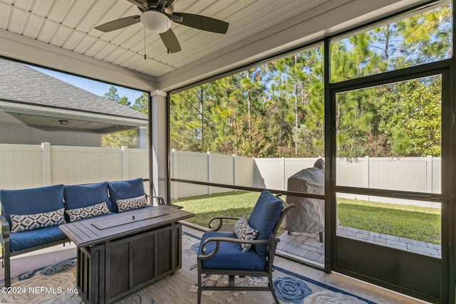 sunroom with ceiling fan and wooden ceiling