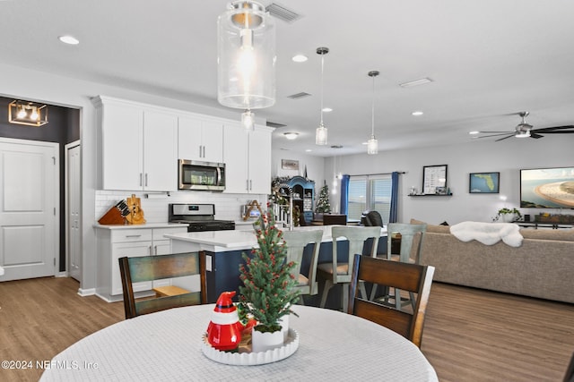 dining room with ceiling fan and wood-type flooring