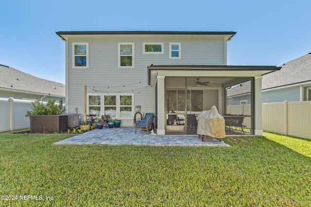 rear view of property with a patio, ceiling fan, a lawn, and a sunroom