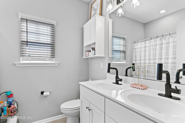 bathroom featuring vanity, toilet, and walk in shower