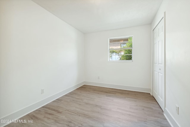 unfurnished bedroom featuring a closet and light hardwood / wood-style flooring