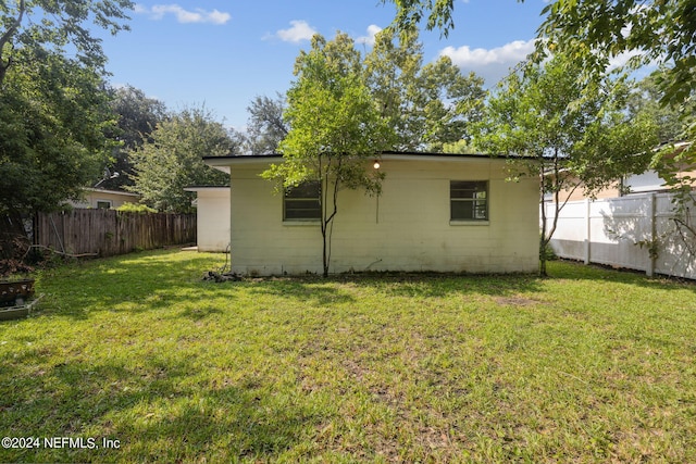 back of property featuring a lawn