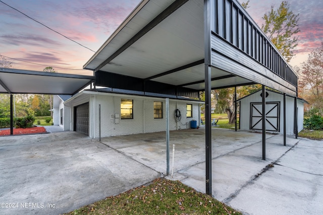 garage at dusk featuring a carport