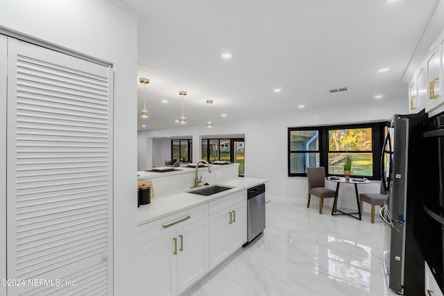 kitchen featuring white cabinetry, sink, stainless steel appliances, and decorative light fixtures