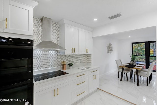 kitchen with black appliances, white cabinetry, wall chimney range hood, and backsplash