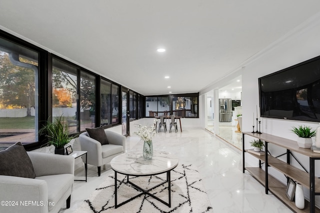 living room featuring crown molding and a wall of windows