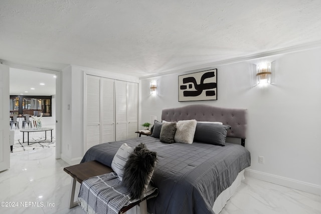 bedroom with a textured ceiling and a closet