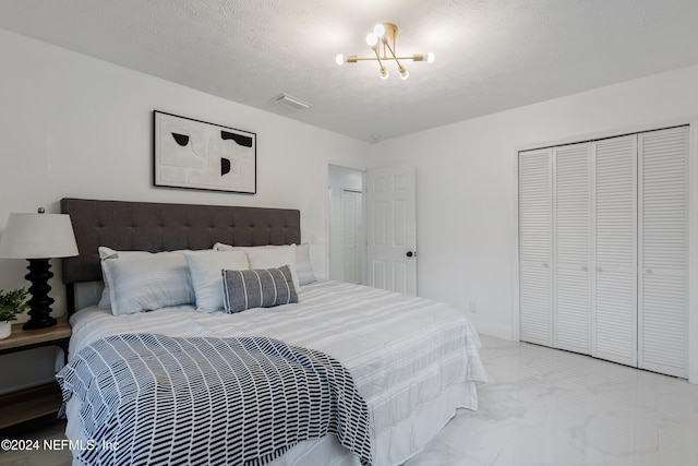 bedroom featuring a chandelier, a textured ceiling, and a closet