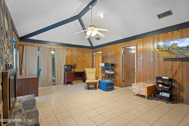 living area featuring ceiling fan, lofted ceiling with beams, wood walls, a textured ceiling, and light tile patterned floors