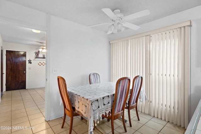 dining area with a textured ceiling, ceiling fan, and light tile patterned flooring