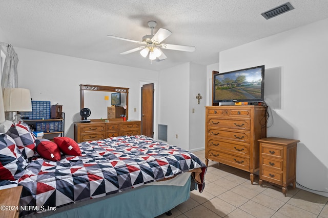 tiled bedroom with a textured ceiling and ceiling fan