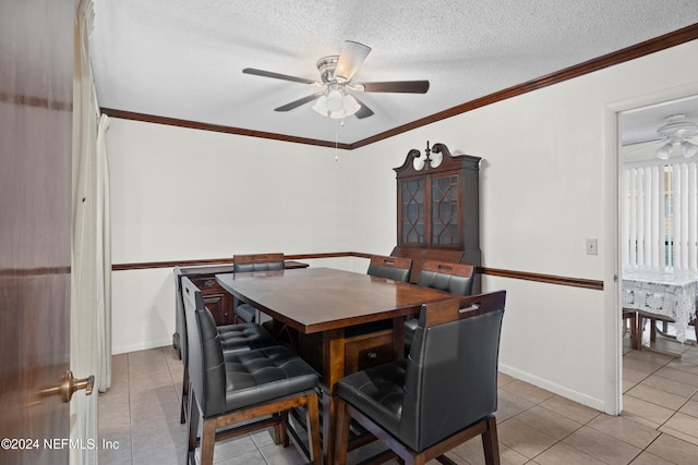 dining room with ceiling fan, light tile patterned floors, a textured ceiling, and ornamental molding