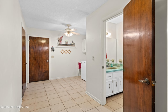 interior space featuring light tile patterned floors, a textured ceiling, and sink