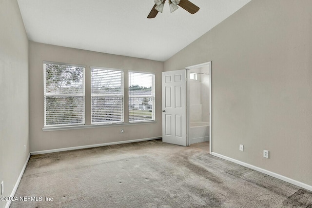 unfurnished bedroom with ceiling fan, ensuite bathroom, vaulted ceiling, and light carpet