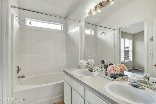 bathroom with tiled shower / bath, vanity, and a wealth of natural light